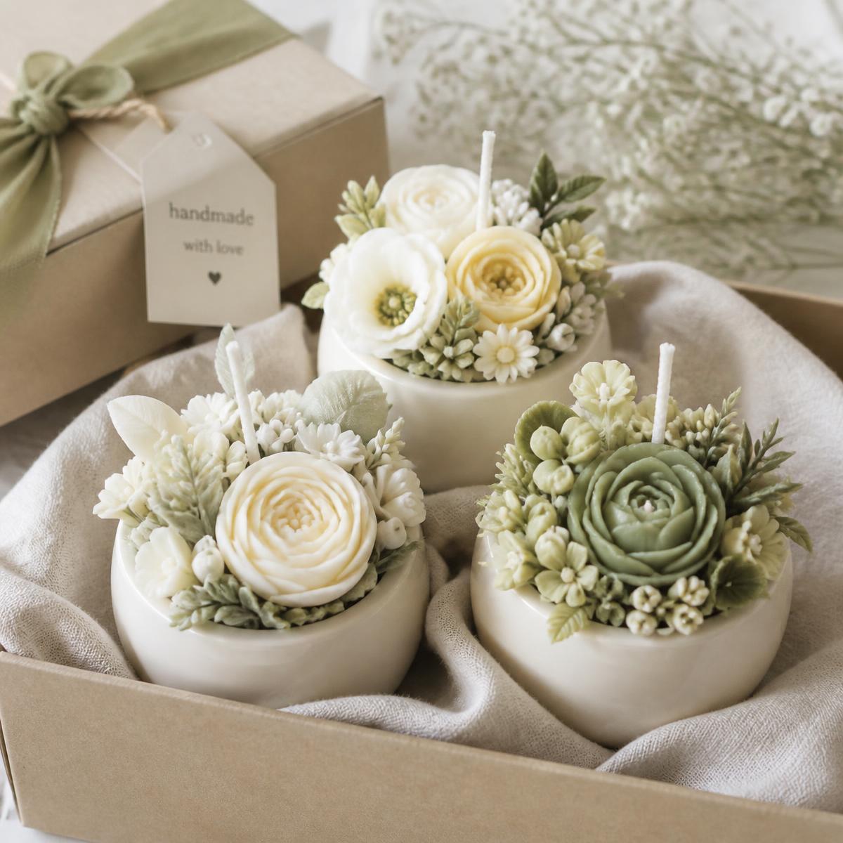 Pack de tres velas florales artesanales en maceteros de cerámica dentro de caja de regalo con cinta verde salvia